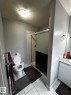 Three-quarter bathroom featuring a shower with a sliding glass door, a toilet, and a single vanity with a laminate countertop - 1868 30 Street Nw, Edmonton, AB  - Indoor Photo Showing Bathroom 