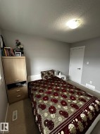 Bedroom featuring neutral gray walls, carpeting, and a flush-mount ceiling light fixture - 