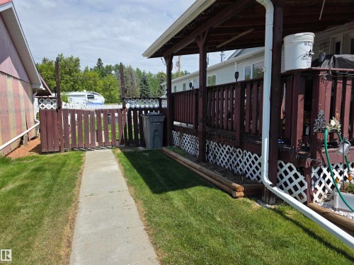 Covered wooden deck with railing and lattice skirting - 5012 53 Ave, Breton, AB 
