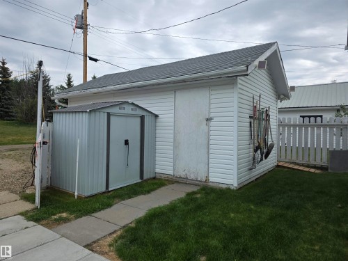 Detached accessory building featuring white vinyl siding and a gray shingle roof - 5012 53 Ave, Breton, AB 