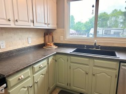 Kitchen workspace featuring a black drop-in sink with a chrome faucet - 