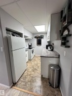 Galley kitchen featuring white appliances. - 