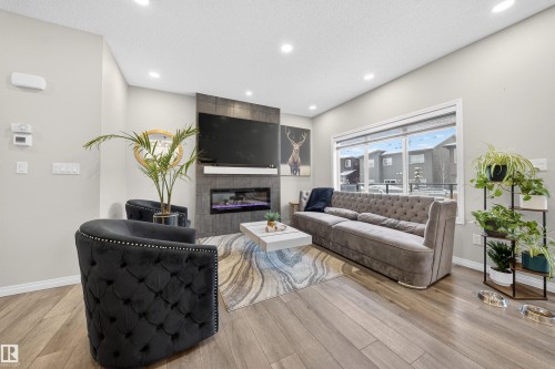 Living room featuring light-toned walls, recessed lighting, and wood-finish flooring - 6085 King Landing, Edmonton, AB - Indoor With Fireplace