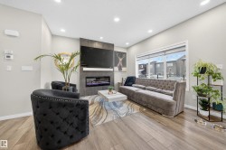Living room featuring light-toned walls, recessed lighting, and wood-finish flooring - 