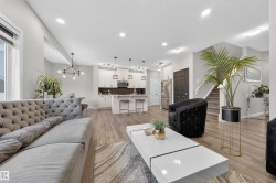 Expansive open-concept living area featuring wood-finish flooring, recessed lighting, and a contemporary kitchen - 