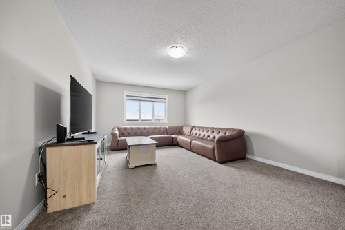 Spacious room featuring neutral tone carpeting, light grey wall paint, and a window for natural illumination - 6085 King Landing, Edmonton, AB - Indoor