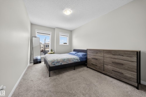Carpeted bedroom with two windows, painted in a neutral tone - 6085 King Landing, Edmonton, AB - Indoor Photo Showing Bedroom