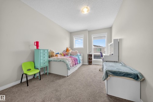Carpeted room featuring light neutral wall paint, white trim, and a textured ceiling - 6085 King Landing, Edmonton, AB - Indoor Photo Showing Bedroom
