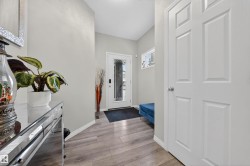 Entryway featuring wood-finish flooring, light grey walls, and white trim - 