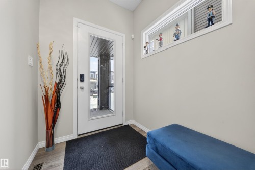 Entryway featuring a full-light entry door with a smart lock, light gray wall paint, and wood-finish flooring - 6085 King Landing, Edmonton, AB - Indoor Photo Showing Other Room