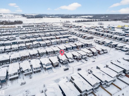 Residential neighborhood featuring multiple detached homes with snow-covered roofs and a distant treeline - 6085 King Landing, Edmonton, AB - Outdoor With View