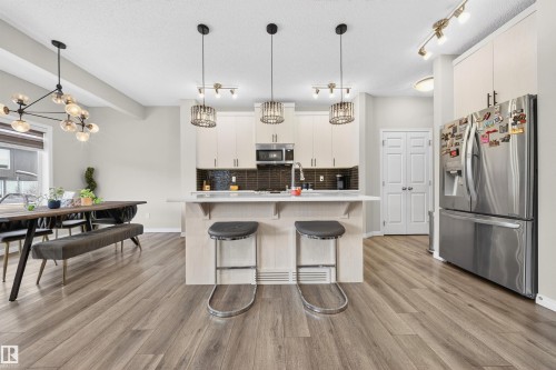 Open-concept kitchen and dining area featuring wood-finish flooring - 6085 King Landing, Edmonton, AB - Indoor Photo Showing Kitchen With Upgraded Kitchen