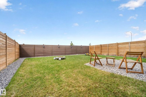 Expansive backyard featuring a manicured lawn, a gravel border, and a gravel patio area - 3337 Kulay Way, Edmonton, AB - Outdoor