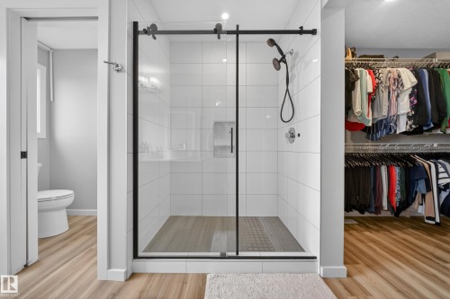 Walk-in shower with clear glass enclosure, matte black hardware, and white subway tile surround - 3337 Kulay Way, Edmonton, AB - Indoor Photo Showing Bathroom