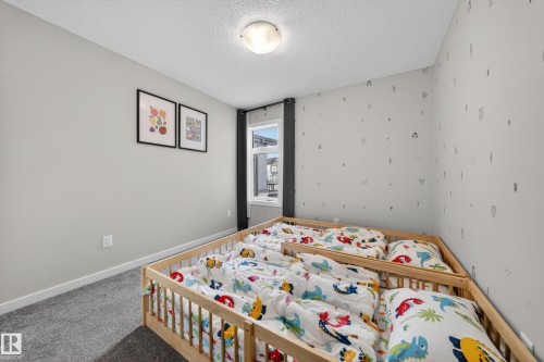 Bedroom featuring light gray wall paint, patterned wallpaper, a window with dark drapes, and gray carpeting - 3337 Kulay Way, Edmonton, AB - Indoor Photo Showing Bedroom