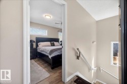 Bedroom with wood-finish flooring, a transom window, and a ceiling fan - 