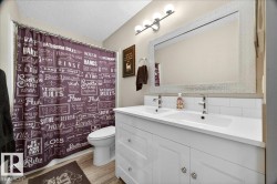Double vanity with integrated sinks, white cabinetry, and polished chrome faucets - 