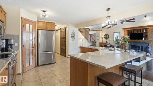 Kitchen with light wood cabinetry, stone-look tile flooring, and a stone-look backsplash - 4309 37A Avenue, Edmonton, AB - Indoor Photo Showing Kitchen