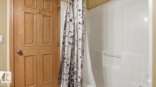 White shower surround with integrated grab bar - 4309 37A Avenue, Edmonton, AB - Indoor Photo Showing Bathroom
