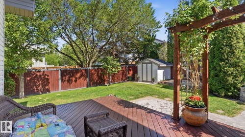 Expansive backyard featuring a brown composite deck with an overhead pergola, a stone patio area, and a storage shed - 4309 37A Avenue, Edmonton, AB - Outdoor