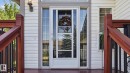White vinyl siding exterior with a storm door, flanked by sidelight windows and a transom window above - 4309 37A Avenue, Edmonton, AB  - Outdoor With Exterior 