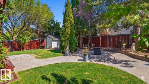 Landscaped backyard featuring a paver patio and walkways, a manicured lawn, and mature trees - 4309 37A Avenue, Edmonton, AB - Outdoor