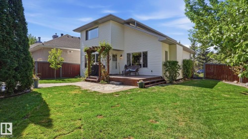 Expansive backyard featuring a manicured lawn, a multi-level wood-finish deck, and a stone patio area - 4309 37A Avenue, Edmonton, AB - Outdoor
