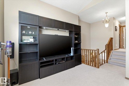 Built-in media console with storage, glass-front cabinetry, and integrated lighting - 442 Hunters Green, Edmonton, AB - Indoor