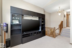 Built-in media console with storage, glass-front cabinetry, and integrated lighting - 