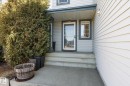 Inviting front entrance featuring a glass storm door, an adjacent sidelite window, and a covered porch - 442 Hunters Green, Edmonton, AB  - Outdoor With Exterior 