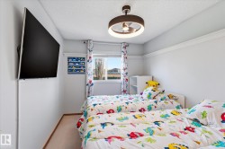 Bright interior space with a ceiling-mounted light fixture and a wall-mounted flat-screen television - 