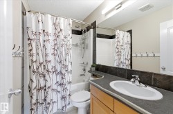 Full bathroom featuring a single vanity with a laminate countertop, undermount sink, and chrome faucet - 