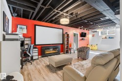 Finished lower level featuring a large projection screen and built-in electric fireplace - 