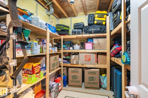 Dedicated storage room with extensive built-in shelving, exposed ceiling joists, utility insulation, and a concrete floor - 442 Hunters Green, Edmonton, AB - Indoor