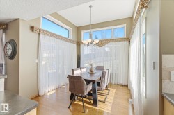 Dining area featuring large windows, wood-finish flooring, and a chandelier - 