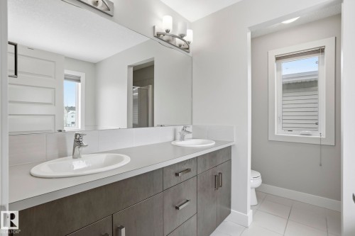 Double vanity with undermount sinks and chrome faucets - 1915 77 Street, Edmonton, AB - Indoor Photo Showing Bathroom