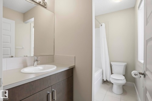 Bathroom featuring a vanity with a white oval sink, chrome faucet, and dark wood-finish cabinetry - 1915 77 Street, Edmonton, AB - Indoor Photo Showing Bathroom