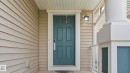 Front entrance featuring a paneled door, exterior wall lantern, and column with railing - 1915 77 Street, Edmonton, AB  - Outdoor With Exterior 