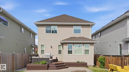 Two-story residence featuring light beige horizontal siding and a brown shingle roof - 1915 77 Street, Edmonton, AB - Outdoor With Deck Patio Veranda With Exterior