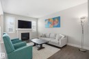 Spacious living area featuring a fireplace with a mantel, hard surface flooring, and white window shutters - 1915 77 Street, Edmonton, AB  - Indoor Photo Showing Living Room With Fireplace 