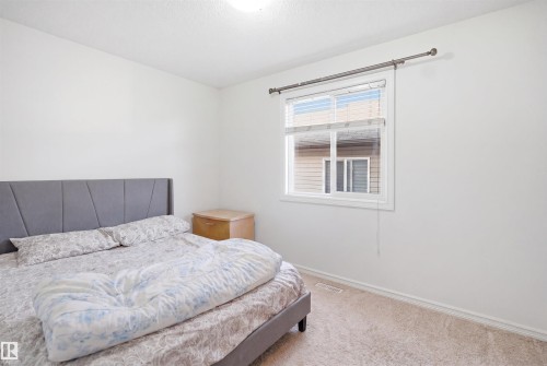 Bright room featuring neutral carpeting, white walls, a single window with blinds, and white baseboards - 1523 36 Avenue, Edmonton, AB - Indoor Photo Showing Bedroom