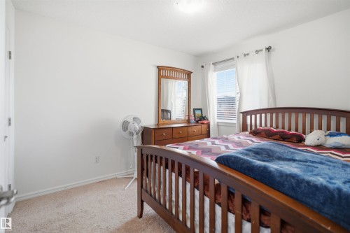 Bedroom featuring neutral carpeting, white walls, and a window with horizontal blinds and sheer curtains - 1523 36 Avenue, Edmonton, AB - Indoor Photo Showing Bedroom