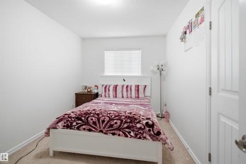 Carpeted room featuring a single window with blinds, white walls, and a ceiling light fixture - 1523 36 Avenue, Edmonton, AB - Indoor Photo Showing Bedroom