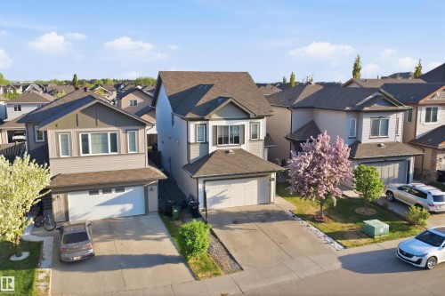 Contemporary suburban home featuring a two-car garage, concrete driveway, and a prominent front bay window - 1523 36 Avenue, Edmonton, AB - Outdoor With Facade