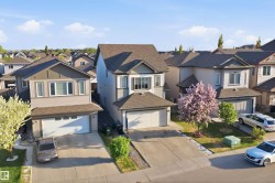 Contemporary suburban home featuring a two-car garage, concrete driveway, and a prominent front bay window - 