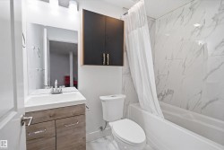 Full bathroom featuring a single vanity with wood-finish cabinetry, a white countertop basin, and a wall-mounted mirror - 