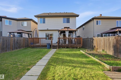 Rear exterior featuring a wooden deck with railing, a sliding glass door, and vinyl siding - 1523 36 Avenue, Edmonton, AB - Outdoor With Deck Patio Veranda