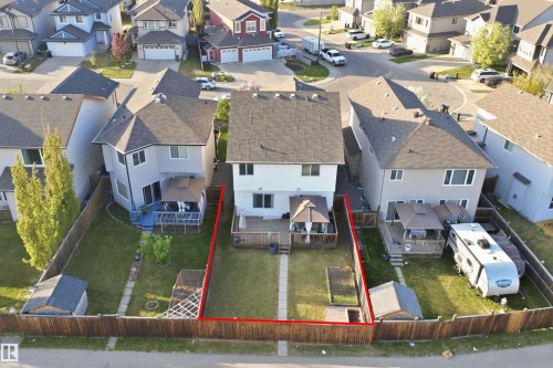 Rear exterior featuring a multi-level deck, dark shingle roof, light-toned siding, and a fenced backyard with a lawn area - 1523 36 Avenue, Edmonton, AB - Outdoor With View