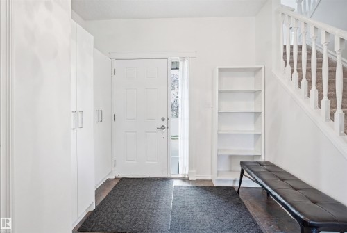 Entryway featuring bright white walls, wood-finish flooring, and a traditional white paneled door with sidelight - 1523 36 Avenue, Edmonton, AB - Indoor Photo Showing Other Room