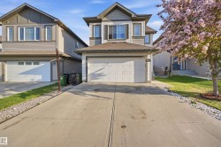 Contemporary two-story residence featuring a front-facing attached garage, concrete driveway, and a gabled roofline - 